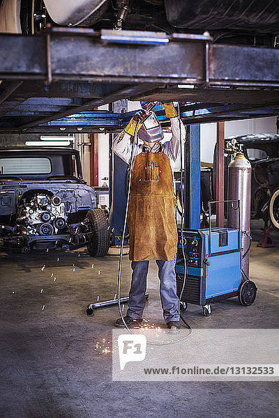 Mechaniker repariert Auto in Autowerkstatt