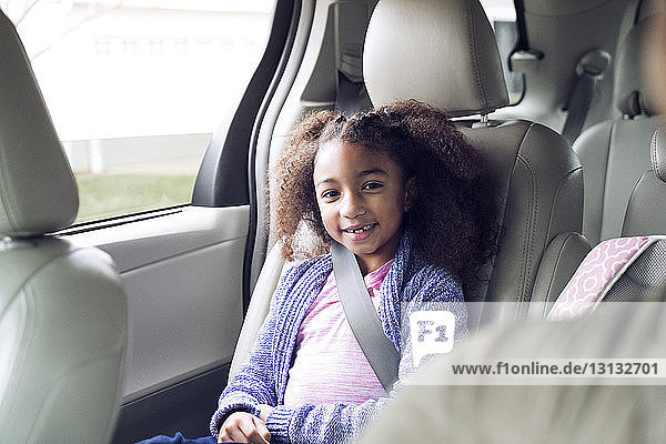 Porträt eines glücklichen Mädchens im Auto sitzend