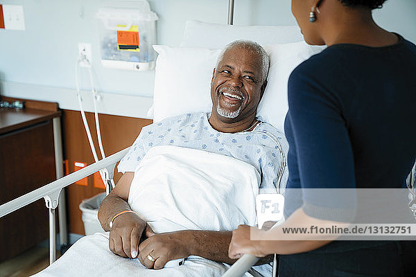 Vater lacht  während er seine Tochter auf der Krankenstation ansieht