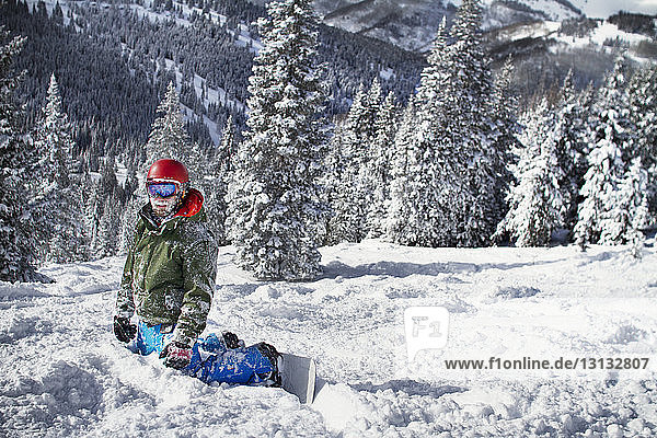 Snowboarder kneeling on snowy mountain