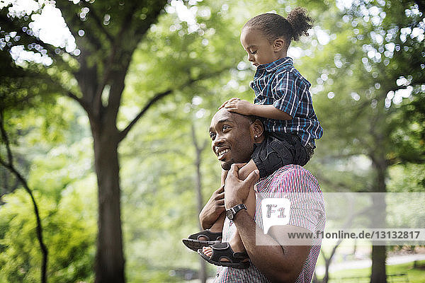 Father carrying son on shoulder at park