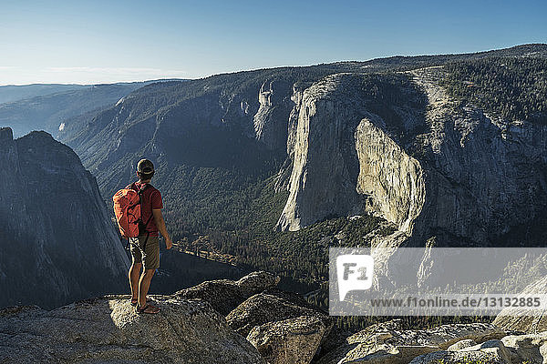 Männlicher Wanderer in voller Länge auf einer Klippe im Yosemite-Nationalpark stehend