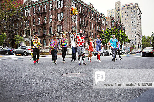 Friends walking on street against buildings in city