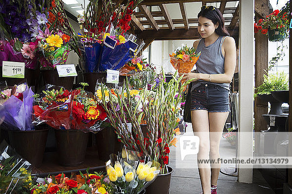 Woman choosing bouquets at flower shop