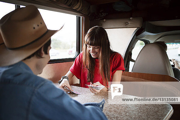 Glückliches Paar spielt Karten  während es im Wohnmobil reist