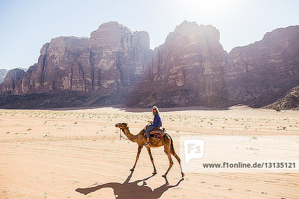 Frau reitet auf Kamel in der Wüste