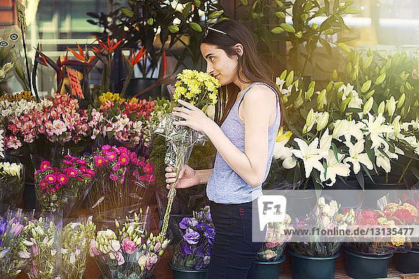 Woman smelling flowers at stall