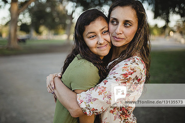 Loving mother embracing daughter at park