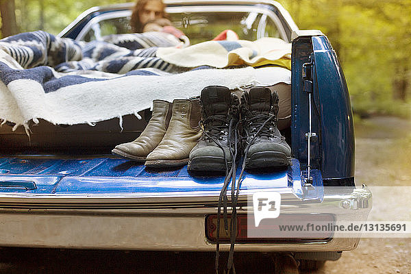 Schuhe auf Pick-up mit entspannendem Paar im Hintergrund