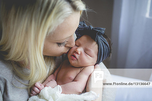 Nahaufnahme einer Mutter  die ein neugeborenes Mädchen zu Hause küsst