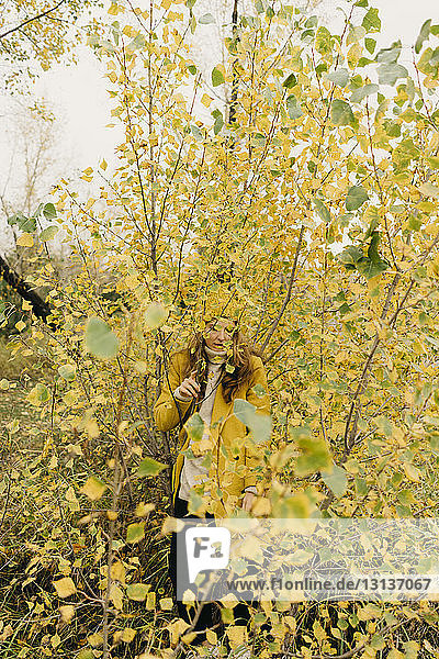 Woman standing amidst plants during autumn