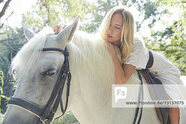 Niedrigwinkelansicht einer Frau  die auf einem Pferd in einem Bauernhof liegt