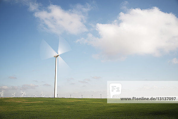 Windturbine in Bewegung auf Feld gegen Himmel