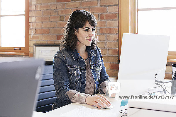 Business woman using desktop computer while working in office