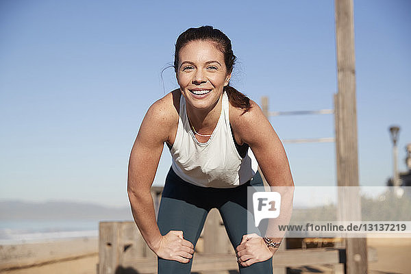 Porträt einer lächelnden Frau beim Sport am Strand