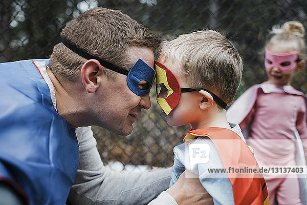 Vater und Junge im Superheldenkostüm mit Tochter