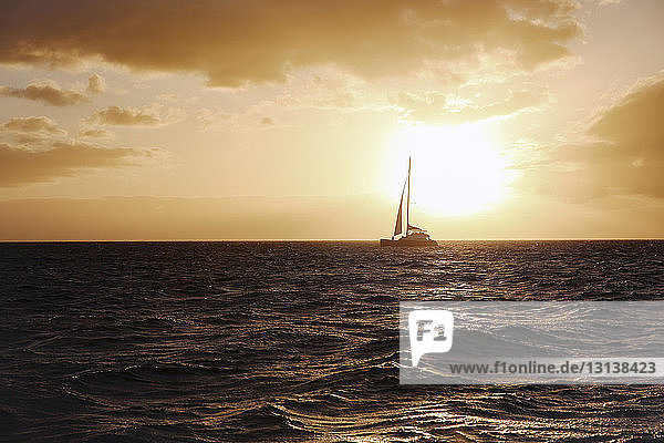 Boot segelt im Meer gegen den Himmel bei Sonnenuntergang
