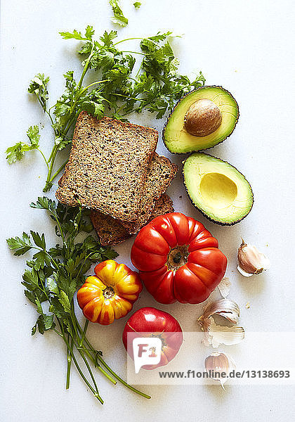 Draufsicht auf Brot  Avocado und Gemüse auf weißem Hintergrund