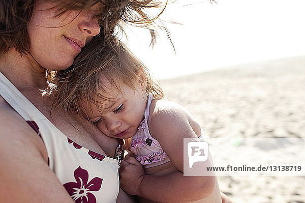 Nahaufnahme einer Mutter mit Mädchen  die an einem sonnigen Tag am Strand steht