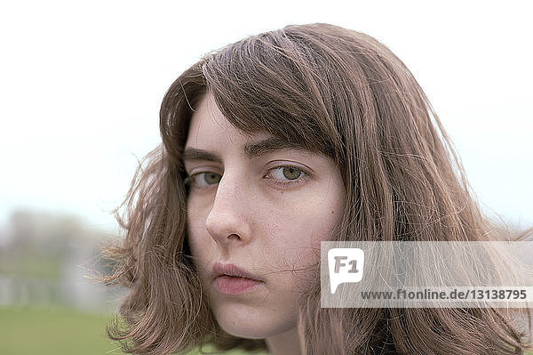 Nahaufnahme-Porträt einer seriösen jungen Frau mit braunen Haaren