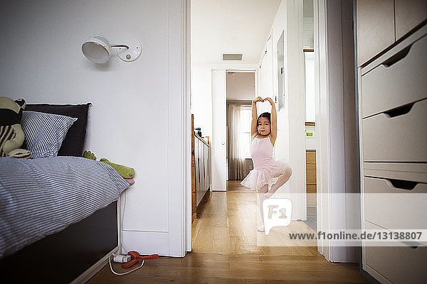 Girl practicing ballet on floor at home