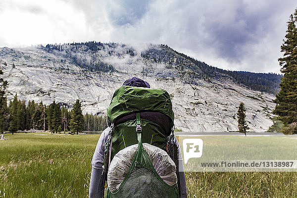 Wanderer mit Rucksack beim Blick auf den Berg im Yosemite-Nationalpark