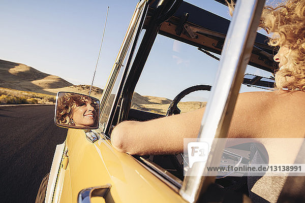 Cropped image of cheerful woman in off-road vehicle