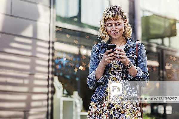 Woman using smart phone while standing