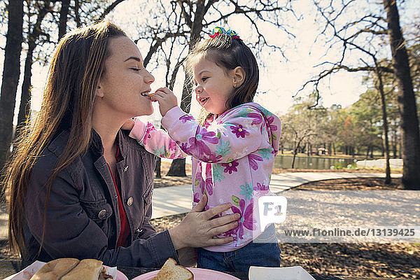 Tochter füttert Mutter im Park