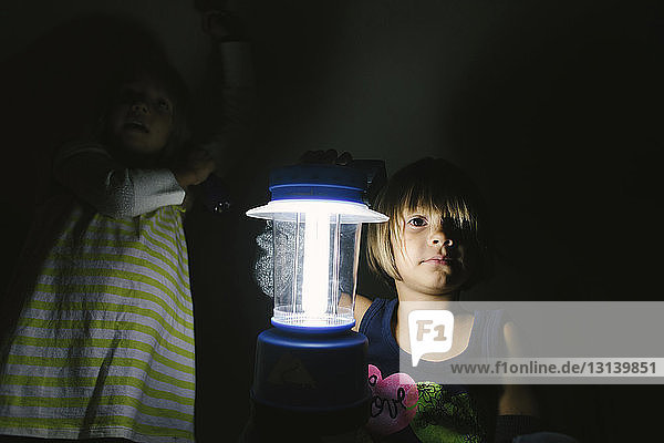 Porträt eines Mädchens mit beleuchteter elektrischer Lampe in der Dunkelkammer