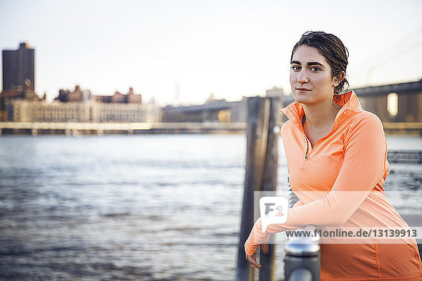 Porträt einer selbstbewussten Sportlerin  die am Beobachtungspunkt am East River steht