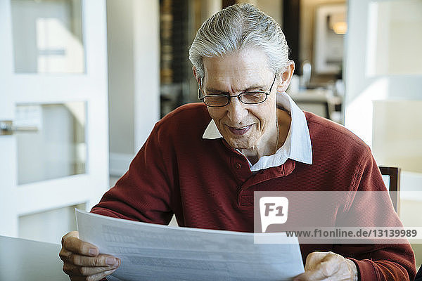 Leitender Mann liest Dokumente im Büro des Finanzberaters