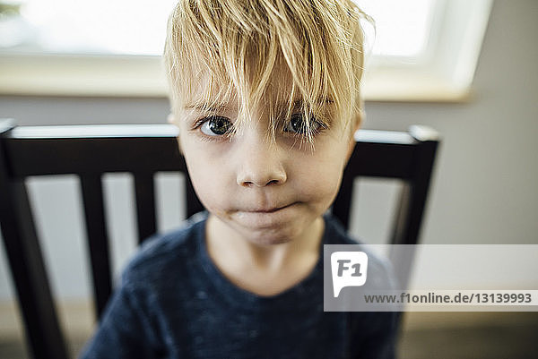 Close-up portrait of boy sitting on chair