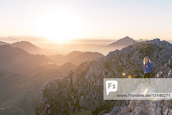 Wanderer steht bei Sonnenaufgang am Piestewa Peak vor klarem Himmel