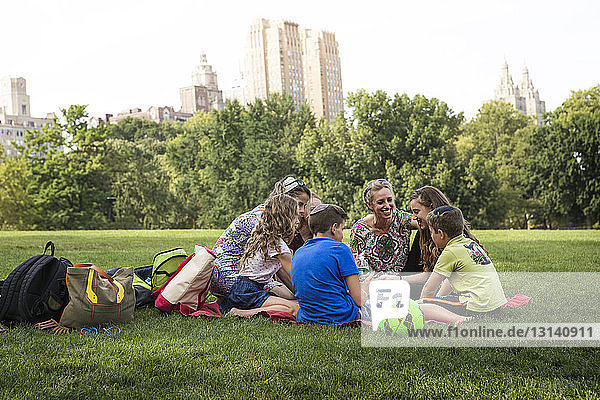 Family and friends enjoying picnic at park in city