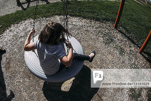 High angle view of girl swinging at playground