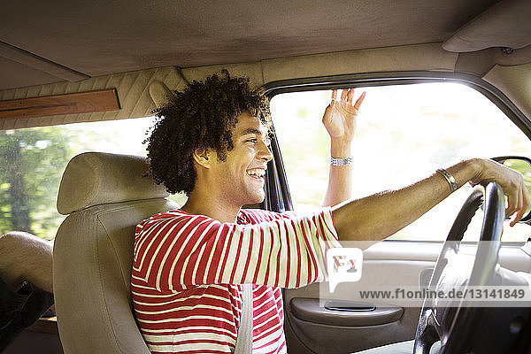 Happy man driving car on sunny day