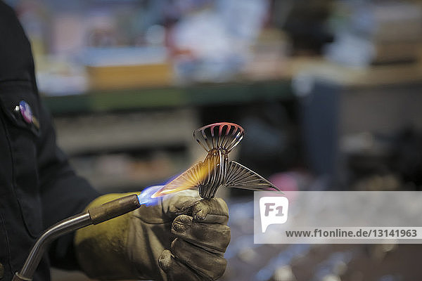 Abgehackte Hand eines Ingenieurs Lötausrüstung mit Propanbrenner in der Fabrik