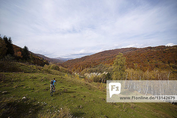 High angle view of man riding bicycle on Carpathian mountains against sky