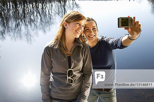 Zwei Frauen mit Kamera am Seeufer
