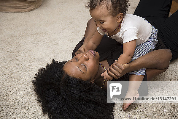 Mid erwachsene Frau spielt mit Kleinkind Tochter auf Teppich