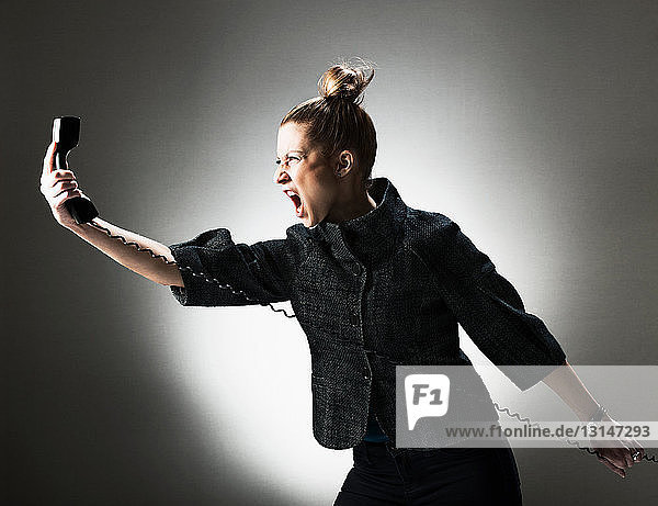 Businesswoman shouting at telephone