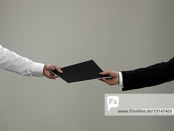 Business man handing folder to colleague