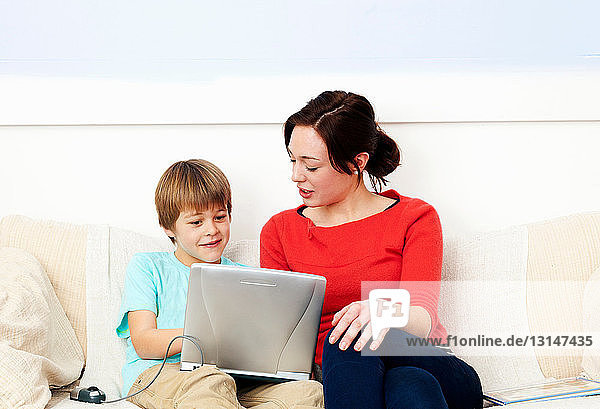 Mother and son using laptop together