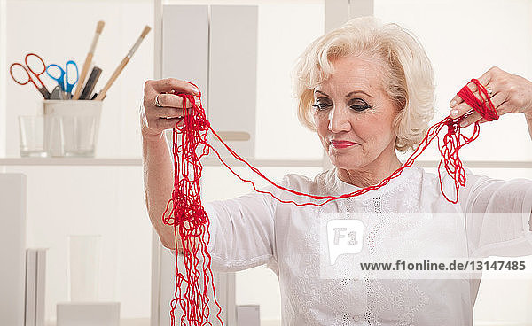 Ältere Frau mit verfilzter Wolle