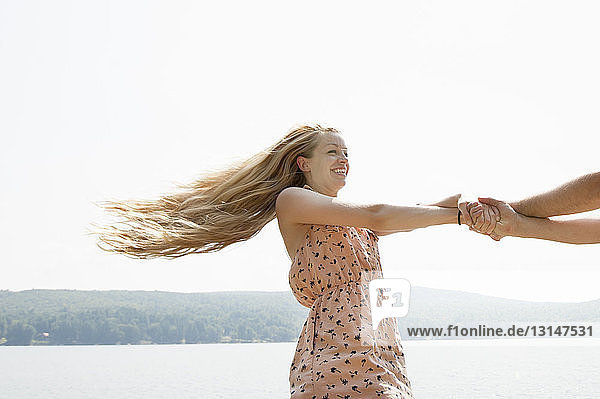 Junges Paar hält sich an den Händen  Frau mit langen blonden Haaren