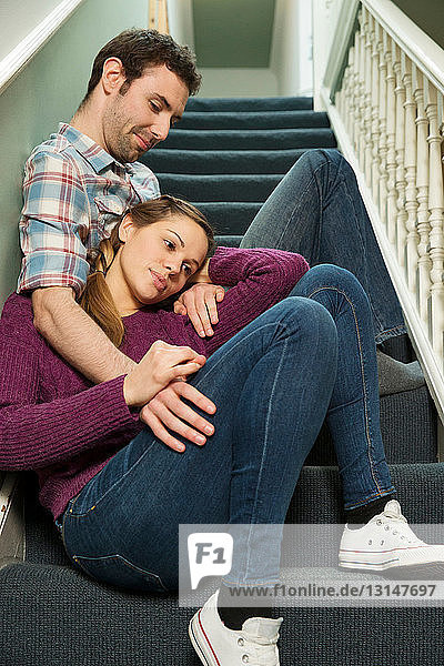 Young couple sitting on staircase