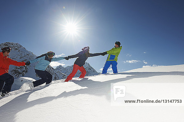 Friends pulling each other uphill in snow  Kuhtai  Austria