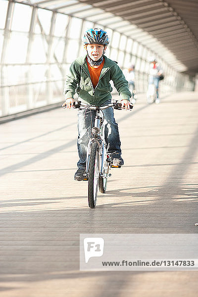 Boy riding bicycle in city tunnel
