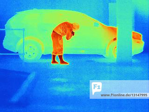 Wärmebildaufnahme eines Einbrechers  der in ein Auto einbricht